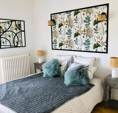 a bedroom with two blue pillows on a bed at LA PARENTHÈSE in Saubrigues