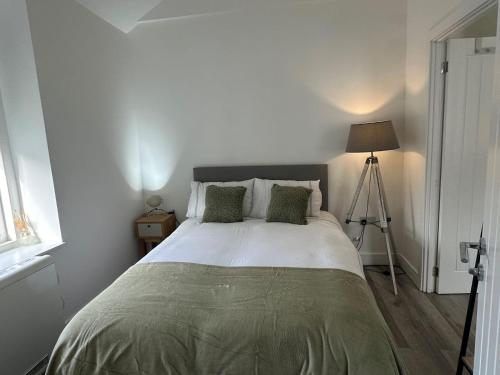 a bedroom with a large bed with a lamp at Carmen Sylva Studio flat Llandudno sea front in Llandudno
