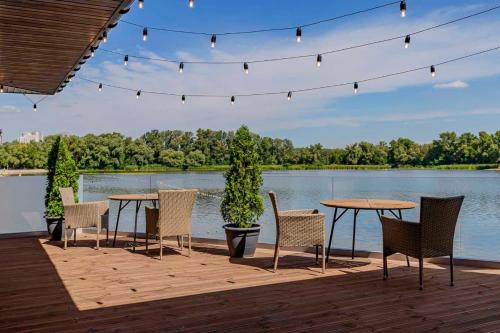 a patio with tables and chairs and a lake at SPA Hotel Galera in Kyiv