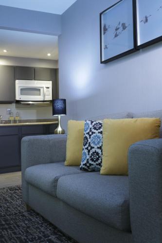 a living room with a couch and a microwave at voco Saltillo Suites by IHG in Saltillo