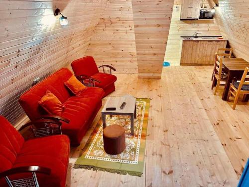 Sea Light في باتومي: غرفة معيشة مع أريكة حمراء وطاولة