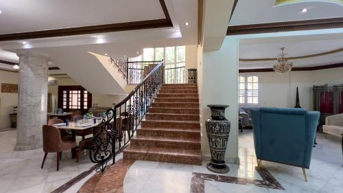 a staircase in a living room with a table and chairs at Turquoise Pyramids palace in Giza