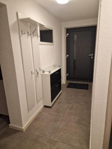 una cocina con armarios blancos y una puerta negra en Ferienwohnung Sumi en Sachsenheim