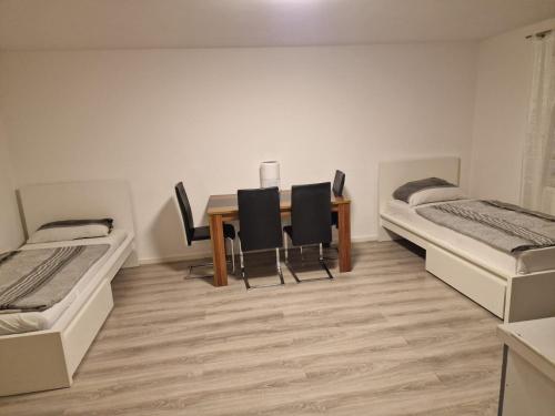 Habitación con mesa de comedor y 2 camas en Ferienwohnung Sumi en Sachsenheim