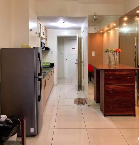 a kitchen with a stainless steel refrigerator and a counter at JT Tagaytay Suites in Tagaytay