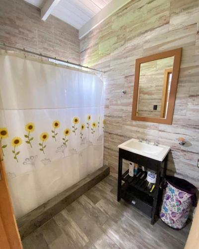 baño con cortina de ducha con girasoles en Cabaña en Villa del Deportista Villa Shalom en Necochea
