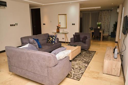 uma sala de estar com dois sofás e uma mesa em Apartment 8 em Acra