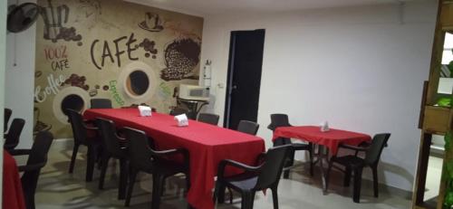 a room with two tables and chairs with red table cloths at Hotel Recuerdos del Estadio in Medellín