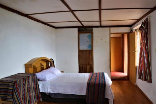 a bedroom with a bed in a room at INKA LAKE Taquile Lodge in Huillanopampa