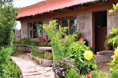 uma casa com um ramo de flores à frente dela em INKA LAKE Taquile Lodge em Huillanopampa