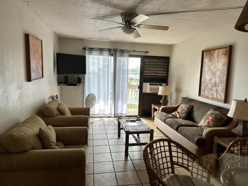 een woonkamer met 2 banken en een tafel bij Banyan Harbor K132 At Kalapaki Beach Condo in Lihue