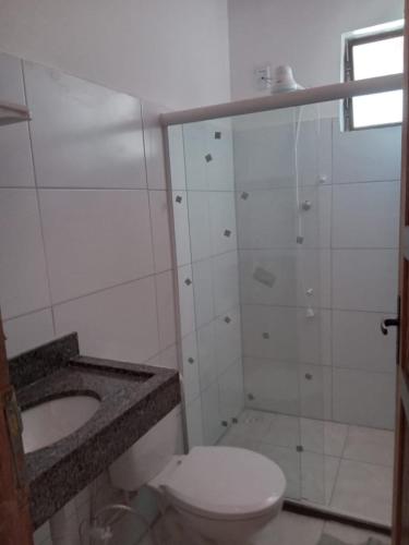 a bathroom with a toilet and a shower and a sink at Casa na Praia de Guaibim- Valença/Bahia in Guaibim