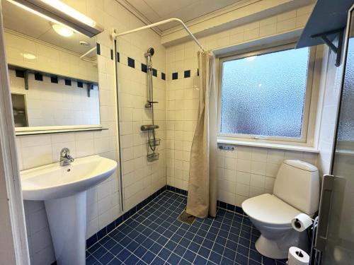 a bathroom with a sink and a toilet and a window at High standard villa in historic Grebbestad in Grebbestad