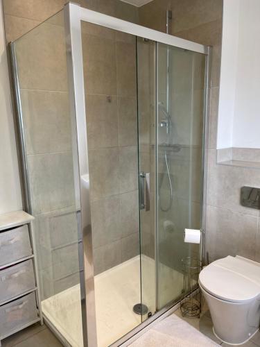 a shower stall in a bathroom with a toilet at En-suite bedroom in a family home near Gatwick airport and Horley station in Hookwood
