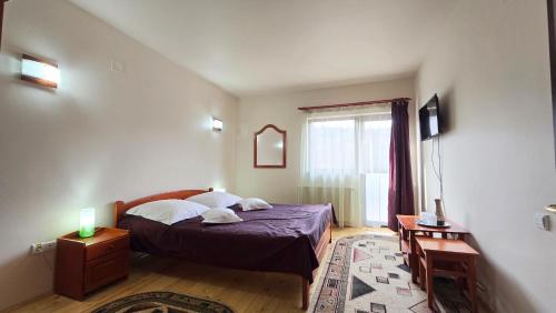 1 dormitorio con cama y ventana en Villa Roua, en Bran