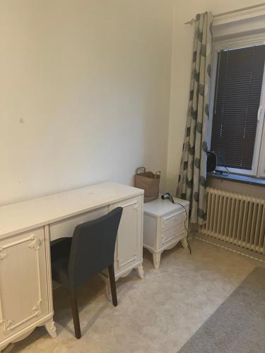 a desk and chair in a room with a window at Stor lägenhet in Malmö