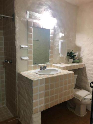 y baño con lavabo, espejo y aseo. en Suit Junior Emano 410 en Ixtapa