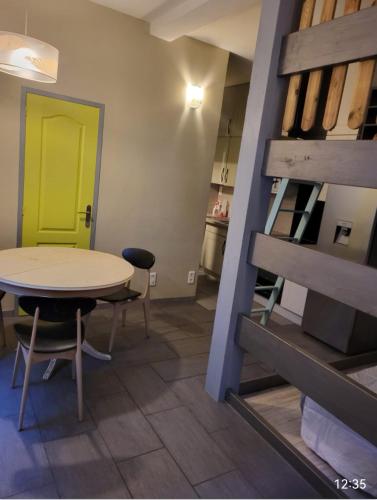 une salle à manger avec une table et une porte jaune dans l'établissement Appartement Rue Frédéric Mistral, à Sète