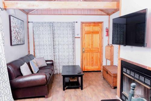 uma sala de estar com um sofá, uma televisão e uma porta em Tiny House em Hulbert