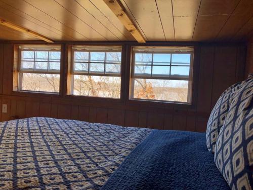 um quarto com três janelas e uma cama em Tiny House em Hulbert