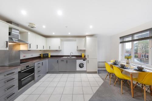 a kitchen with a table and yellow chairs at Deluxe 2-Bedroom Serviced Apartment with Free Parking in High Wycombe