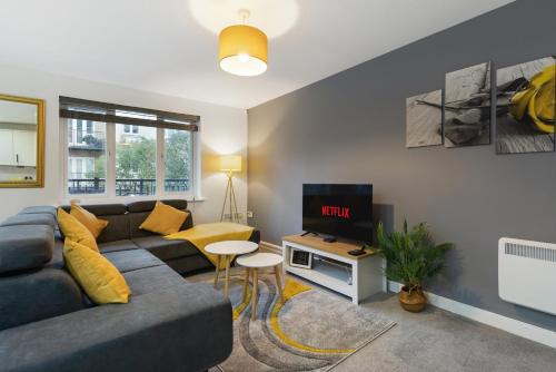 a living room with a couch and a tv at Deluxe 2-Bedroom Serviced Apartment with Free Parking in High Wycombe