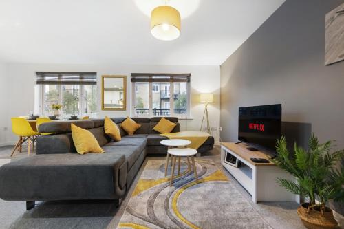 a living room with a couch and a tv at Deluxe 2-Bedroom Serviced Apartment with Free Parking in High Wycombe