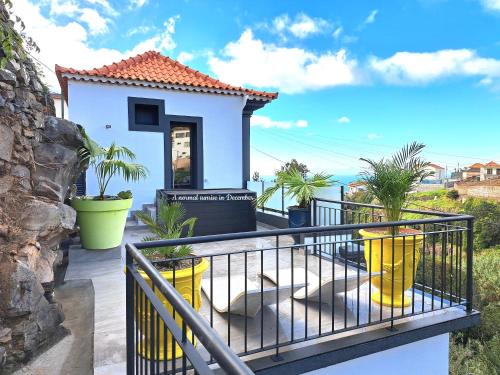 a house with a balcony with a view of the ocean at Espirito do Mar - Premium Villa with Jacuzzi in Estreito da Calheta