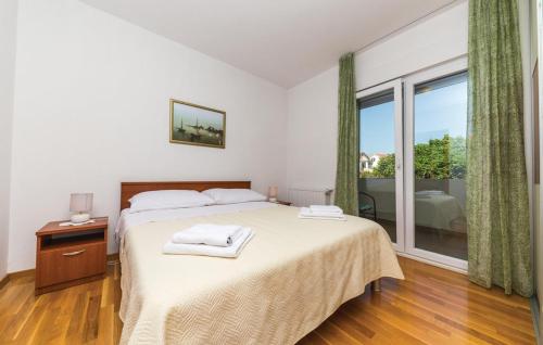 une chambre avec un lit et une grande fenêtre dans l'établissement Apartman Petra, à Kaštela