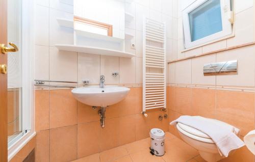 une salle de bain avec un lavabo et des toilettes dans l'établissement Apartman Petra, à Kaštela