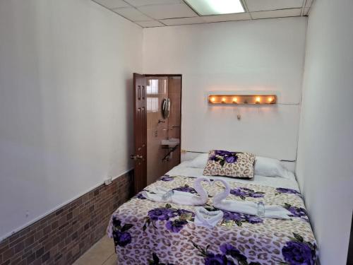 1 dormitorio con 1 cama en una habitación en Hotel Kamelot Parque Central en Quetzaltenango