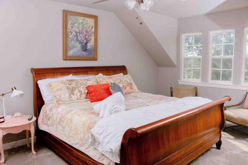 um quarto com uma cama de madeira e almofadas vermelhas em Farm House at Gray House Farm em Hulbert