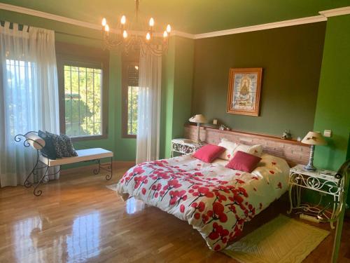 una camera verde con un letto e un lampadario a braccio di LUXURY Positive House Gran Chaparral Toledo a Pepino