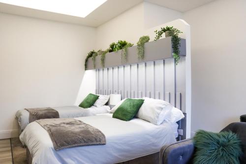 a bedroom with two beds with plants on the wall at Mood Apartment 4 in Bedlington