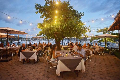 a group of people sitting at tables in a restaurant at Los Suenos Resort Casa Puesta del Sol by Stay in CR in Herradura