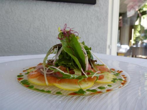 a plate of food with a salad on a table at Hôtel Lou Caleù restaurant le Rocher des Abeilles in Saint-Martin-de-Castillon