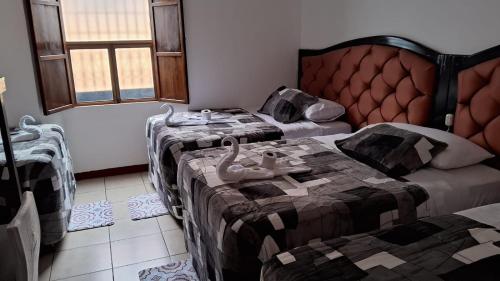Habitación con 2 camas y sofá. en Hotel Kamelot Parque Central en Quetzaltenango