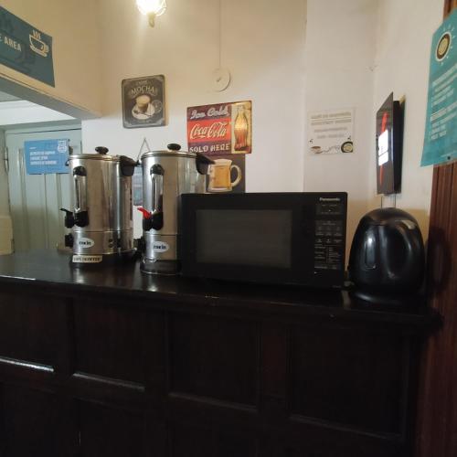 a counter with a microwave and two coffee machines on it at Play Hostel Arcos in Buenos Aires