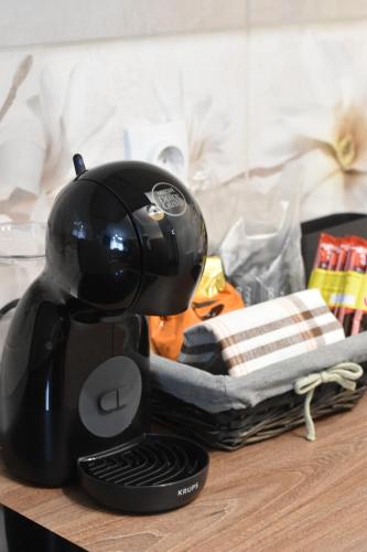 a black coffee maker sitting on top of a table at The NADA APARTMENT of hope in Subotica