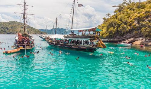 a group of people on a boat in the water at Pousada Caminho do Mar in Paraty