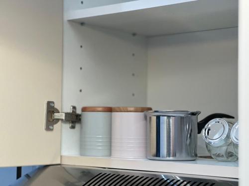 a shelf with pots and pans in a kitchen at The NADA APARTMENT of hope in Subotica