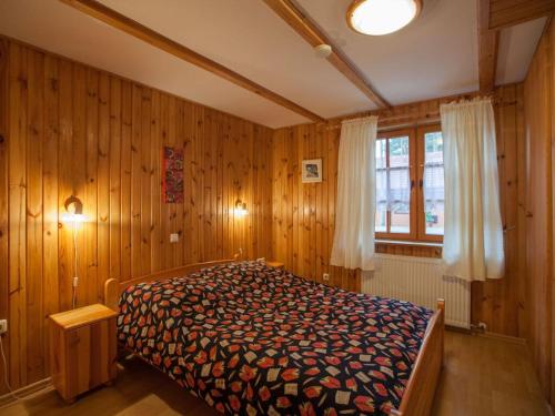 a bedroom with a bed with wooden walls and a window at Four -anniversary Type B in Dźwirzyno