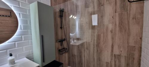 a bathroom with a shower with a wooden wall at Wonderful seaview apartment - Los Cristianos in Arona