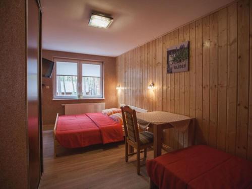 a bedroom with a bed and a table and a window at Holiday apartment four seasons in Dźwirzyno