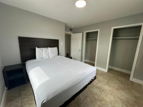 a bedroom with a white bed and two windows at Village Inn Motel in Rockport