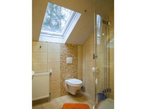a bathroom with a toilet and a shower and a window at Four -anniversary Type C in Dźwirzyno