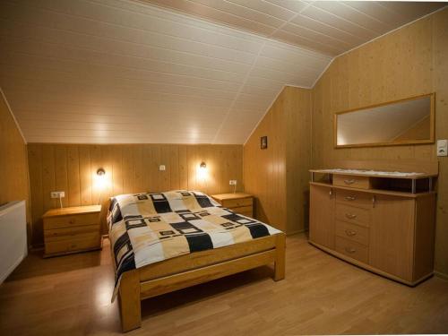 a bedroom with a bed and two dressers in it at Four -anniversary Type C in Dźwirzyno