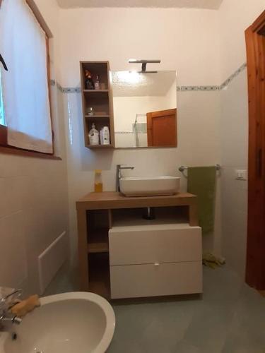 a bathroom with a sink and a toilet and a mirror at Casa a schiera - CÀ MELJ in Rena Majore