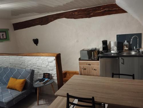 - une cuisine avec une table et un canapé dans une chambre dans l'établissement 35 min Disney - Paris - Family room at homestay with bathtub and dining - lounge area - secure parking - 5 people and 1 baby - duplex with independent entrance on 1rst floor at inhabitant's house, à Coupru