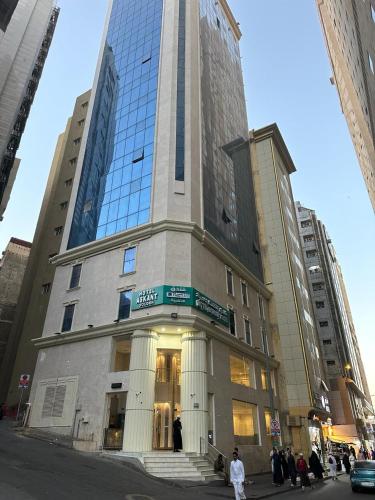 a tall building with people standing in front of it at فندق اسكنت الذهبية - Askant Golden Hotel in An Naqāʼ